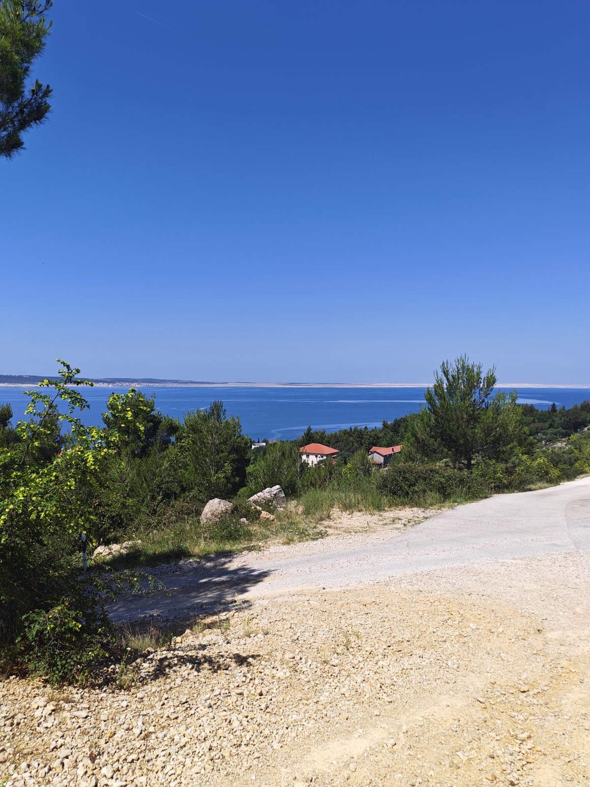 Schotterweg mit Blick hinunter auf Starigrad und das Meer